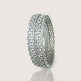 Silver ring with multiple rows of diamonds on a light gray background