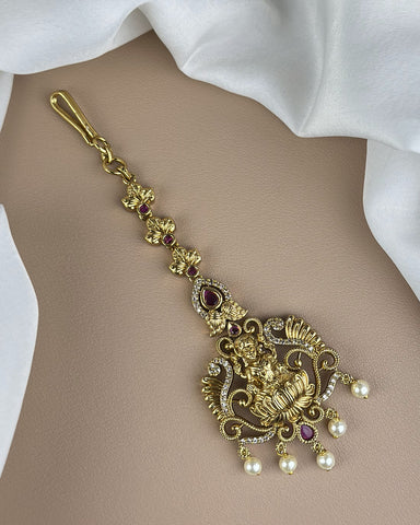 Gold necklace with intricate design and pearls on a mannequin