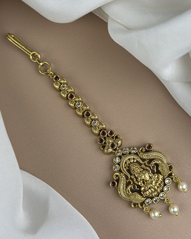 Gold bracelet with decorative elements on a beige background