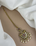 Gold necklace with a decorative pendant on a white fabric background