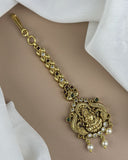 Gold necklace with intricate design and pearls on a beige background