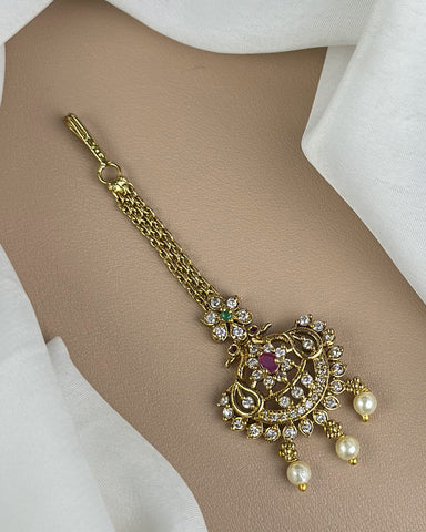 Gold necklace with intricate design and pearls on a beige background