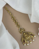 Gold bracelet with intricate design and pendant on a white fabric background