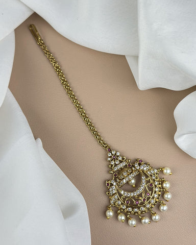 Decorative gold necklace with pearls on a white fabric background