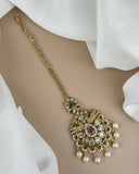 Gold necklace with pearls and gemstones on a beige background