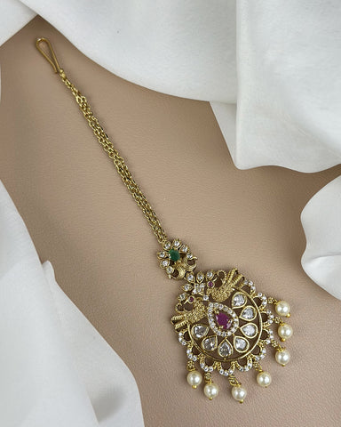 Gold necklace with pearls and gemstones on a beige background