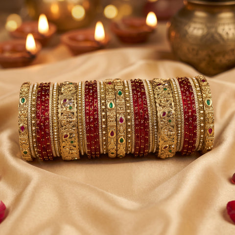 A set of traditional Indian bangles (kara) displayed in a stack. The bangles feature alternating rows of deep red beads and intricate gold-plated metal bands decorated with filigree, small stones, and tiny red and green accents.
