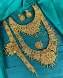 Gold jewelry set on a teal fabric background