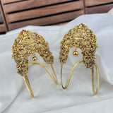 Pair of ornate gold headbands with gemstones on a white fabric background
