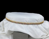 Gold and gemstone necklace on a white fabric background