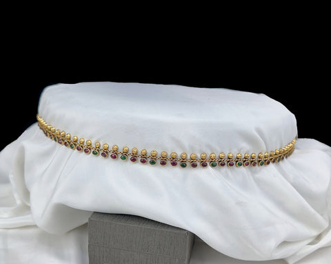 Gold and gemstone necklace on a white fabric background