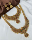 Gold necklace and earrings on a white fabric background