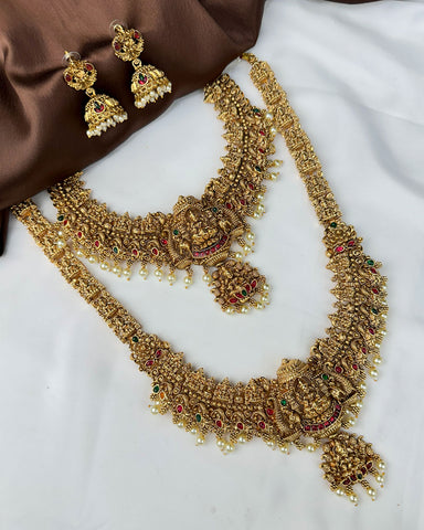 Gold necklace and earrings on a white fabric background