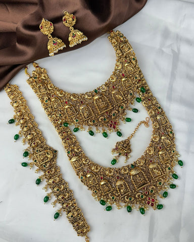 Gold jewelry set with necklace, earrings, and other accessories on a white background