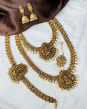 Gold necklace and earrings set on a white and brown fabric background