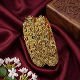 Gold bracelet with intricate designs on a red fabric background