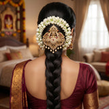 Embellished with shimmering faux diamonds, rich ruby-red stones, and delicate, dangling pearl droplets, this single jadai billa perfectly crowns the braid. It is the ultimate statement accessory for brides, festive occasions, and classical dancers looking for a blend of heritage artistry and contemporary elegance.