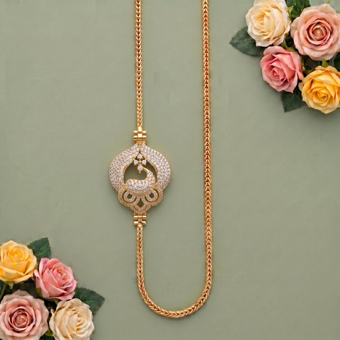 A gold-toned necklace with a decorative circular pendant covered in small clear stones, displayed on a muted green background with pink and cream roses in the corners.