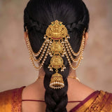 A traditional Indian gold hair ornament (jhumka) with hanging pearl strands, shown from the back on a model with styled black hair.