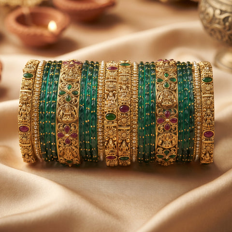A set of traditional Indian bangles (kara) displayed in a row. The set features gold-plated bangles with intricate filigree patterns, some adorned with small green and red stones, alongside multiple thin green beaded bangles.