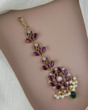 Decorative bracelet with purple stones and gold accents on a person's wrist.