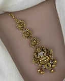 Gold bracelet with intricate designs on a person's wrist