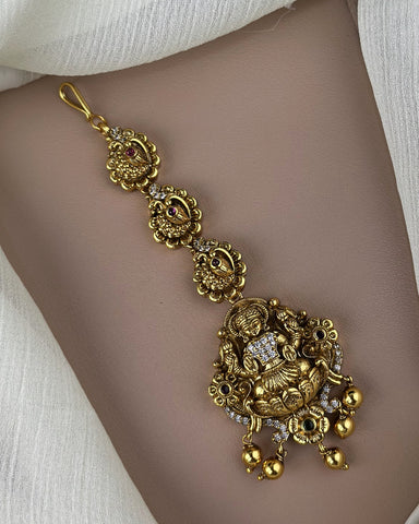 Gold bracelet with intricate designs on a person's wrist