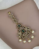 Gold bracelet with pearls and gemstones on a person's wrist