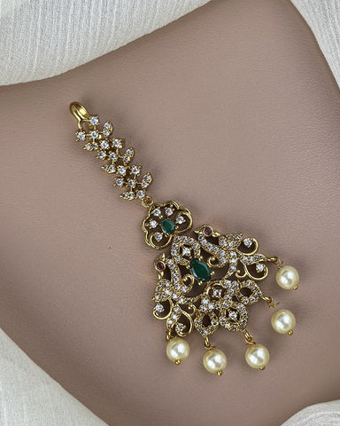 Gold bracelet with pearls and gemstones on a person's wrist