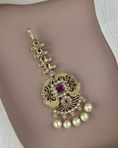 Gold necklace with pearls and gemstones on a neutral background