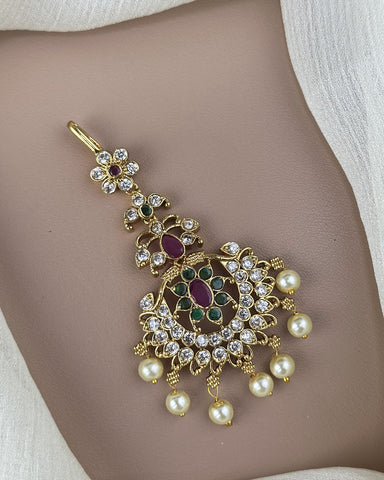 Decorative gold pendant with pearls and gemstones on a skin background