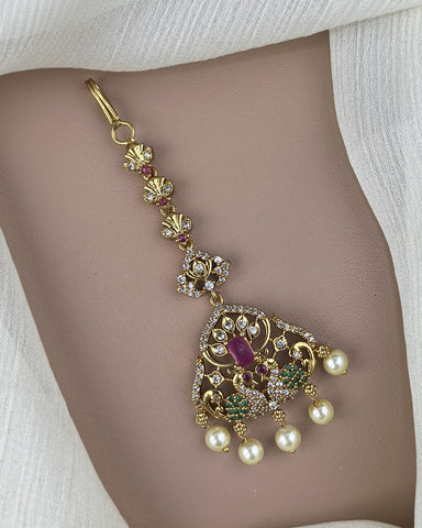 Decorative belly button ring with pearls and gemstones on a model's belly button.