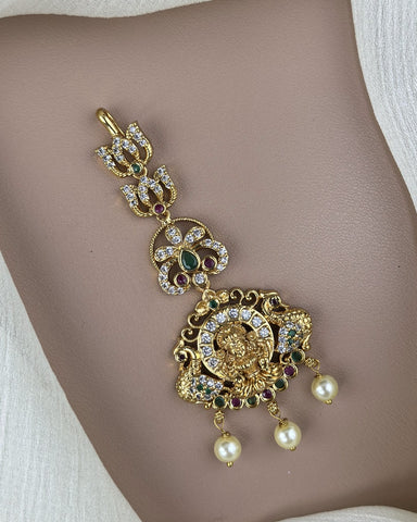 Ornate gold necklace with pearls and gemstones on a mannequin neck.