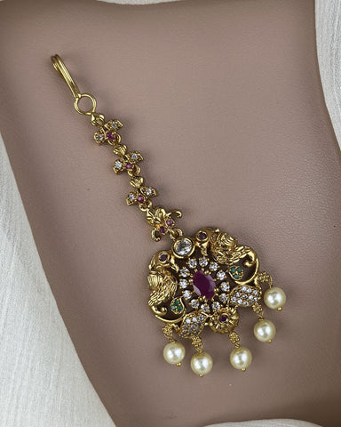 Gold necklace with pearls and gemstones on a neutral background