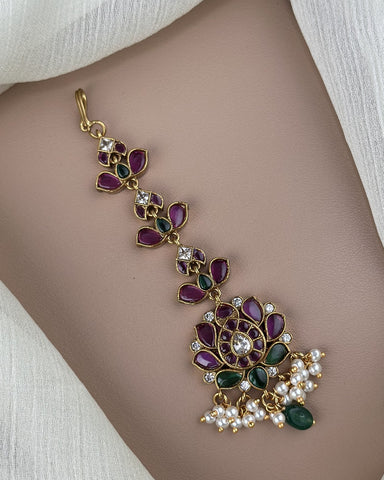 Decorative necklace with gemstones and pearls on a neutral background