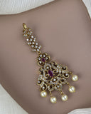 Gold necklace with pearls and gemstones on a neutral background