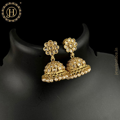 A pair of gold-plated kundan earrings featuring stone studded floral designs with a antique finish.