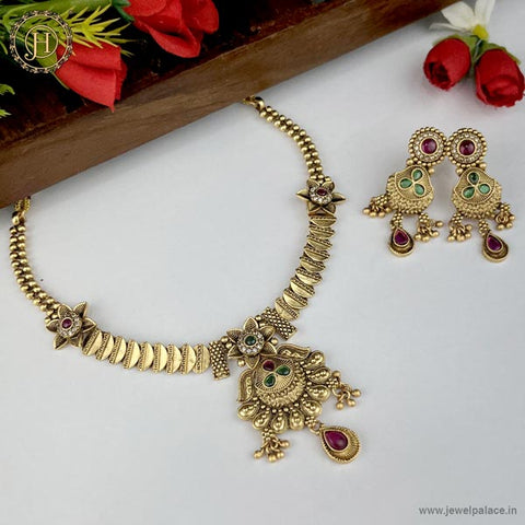 A gold-plated traditional Indian Rajwadi necklace with matching earrings, adorned with AD stones and floral motifs.